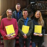 Gruppe der Absolvent+innen und Prüfer vor einer wunderschönen gedrechselten Holzstiege